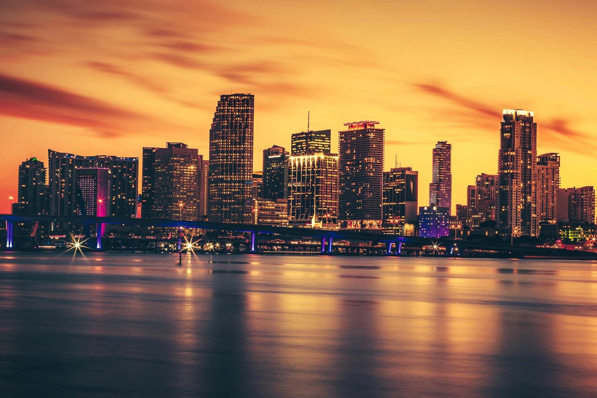 Miami skyline glowing at sunset across Biscayne Bay